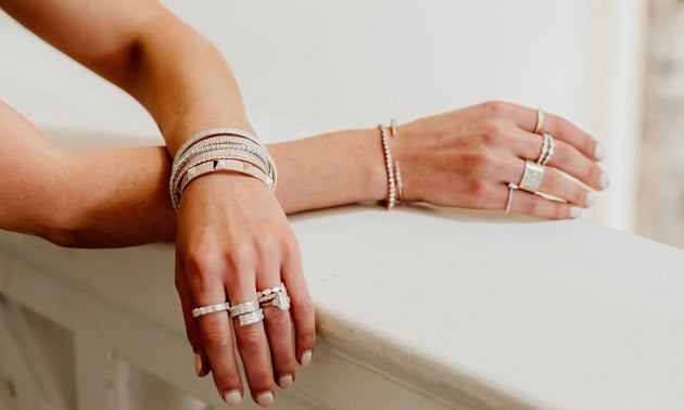 Hands on balcony with diamond rings and bracelets