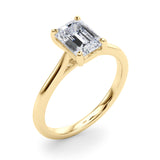 Angle view of emerald solitaire ring in cathedral setting in yellow gold