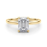 Front view of emerald solitaire ring in cathedral setting in yellow gold