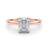 Front view of emerald solitaire ring in cathedral setting in rose gold