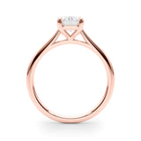 Side view of emerald solitaire ring in cathedral setting in rose gold