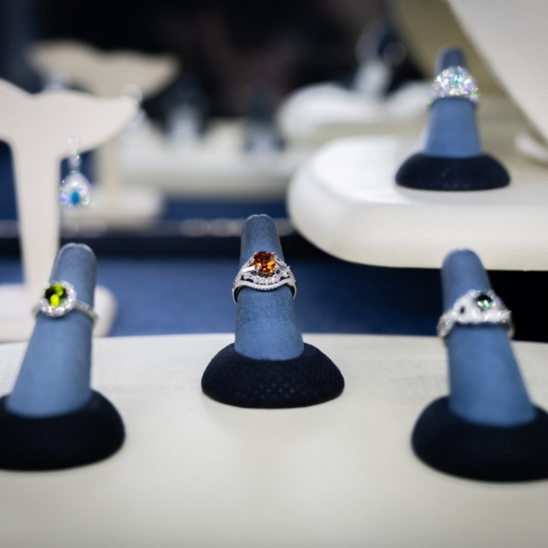 Jewelry display with rings with a color center on blue stands in a store setting
