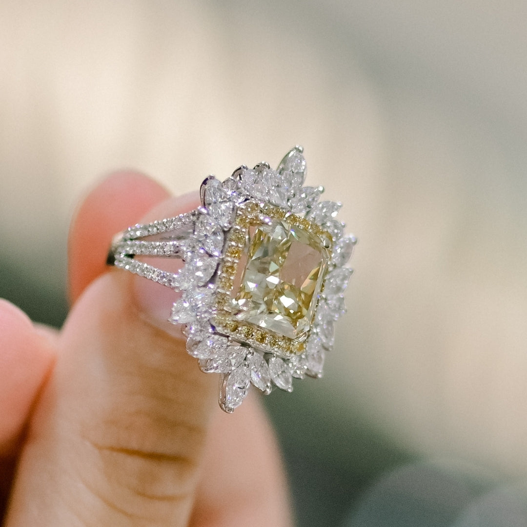 Diamond ring held by a hand with a blurred background