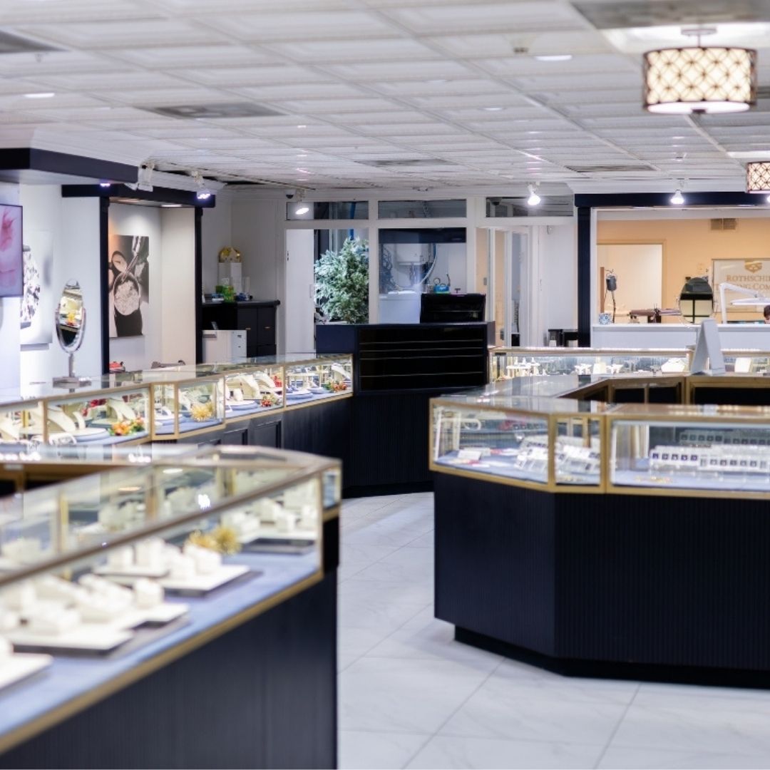 Interior of a Diamonds by Rothschild jewelry store with display cases and counter.