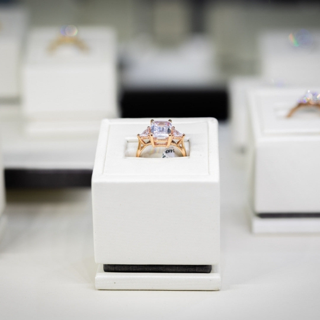 Yellow gold three stone engagement ring in display case