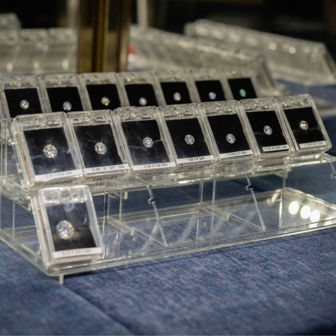 Display of loose natural diamonds in clear cases on a blue surface
