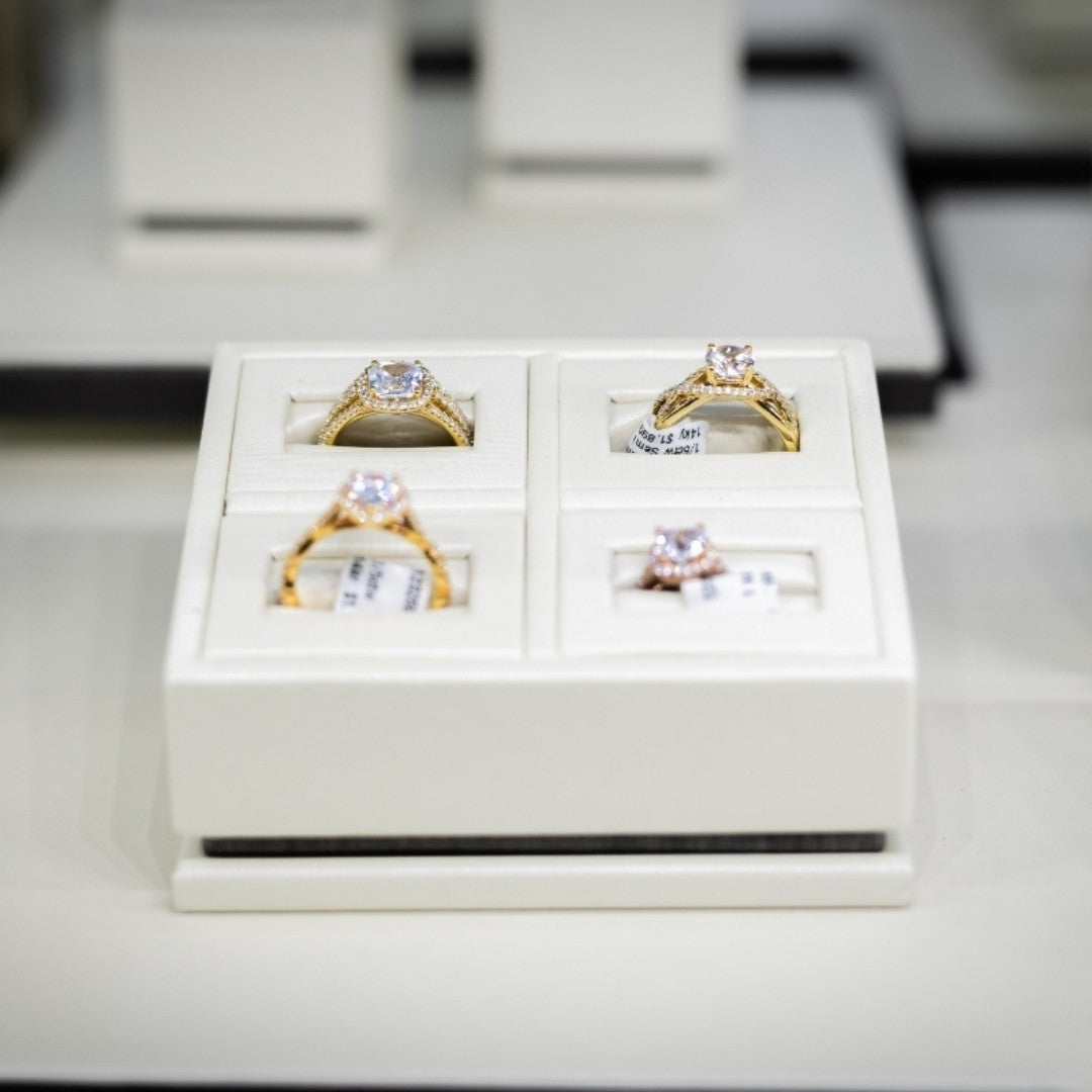 Set of gold and silver rings in a white box on a light gray surface