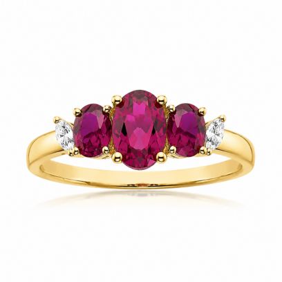 Gold ring with ruby three stones and small diamonds on a white background