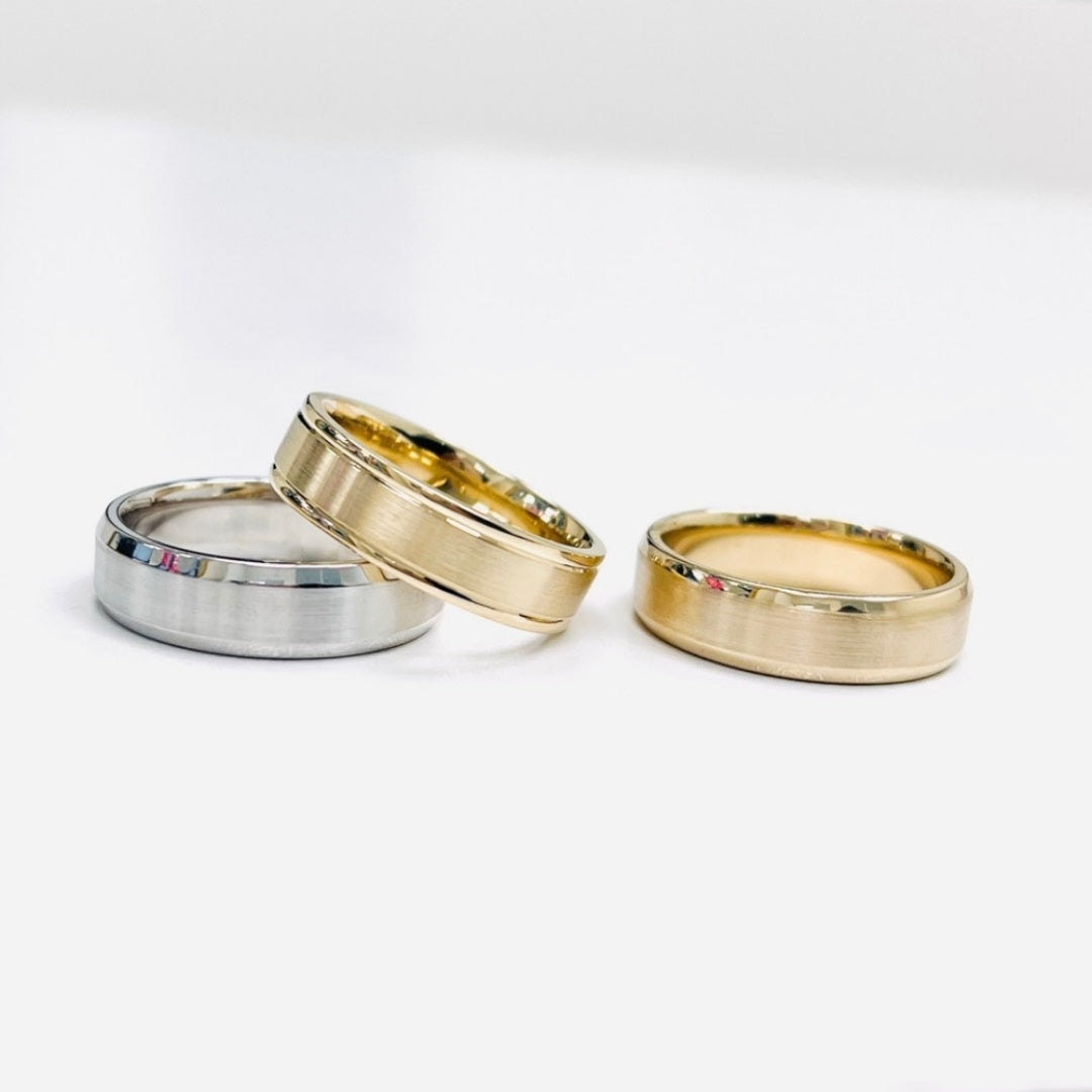 Three wedding rings in gold and silver on a white background