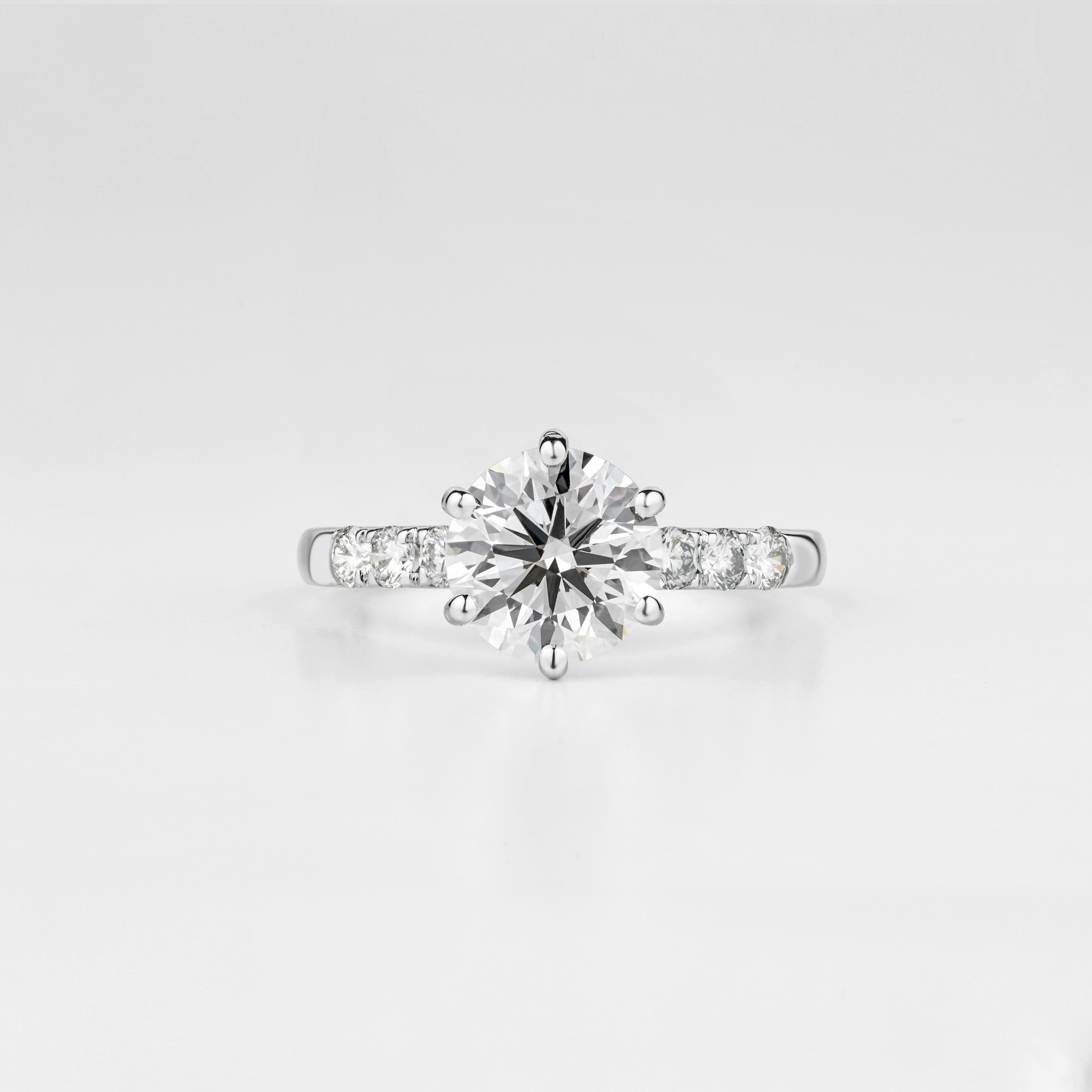 Prong setting with pave band showcases the solitaire diamond